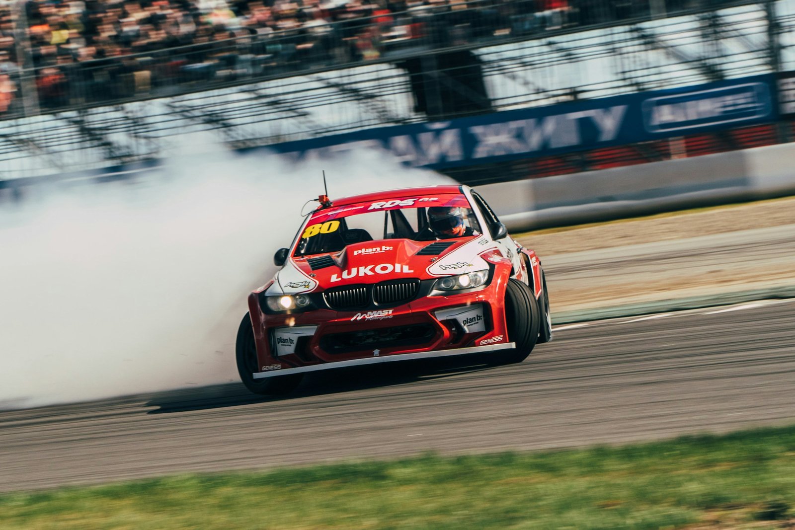 Coche derrapando en circuito con humo de neumáticos