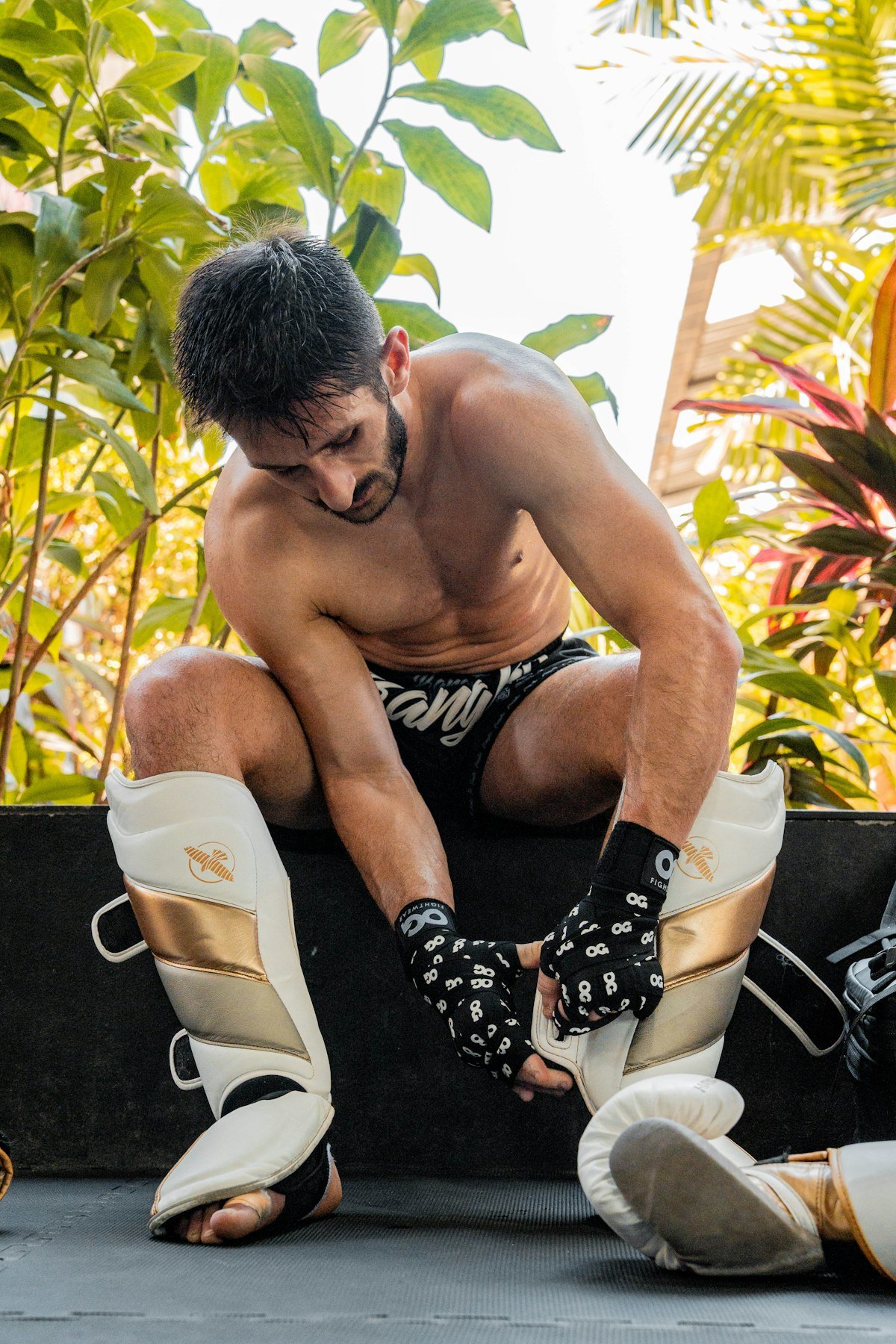 Deportista poniéndose las espinilleras antes de entrenar