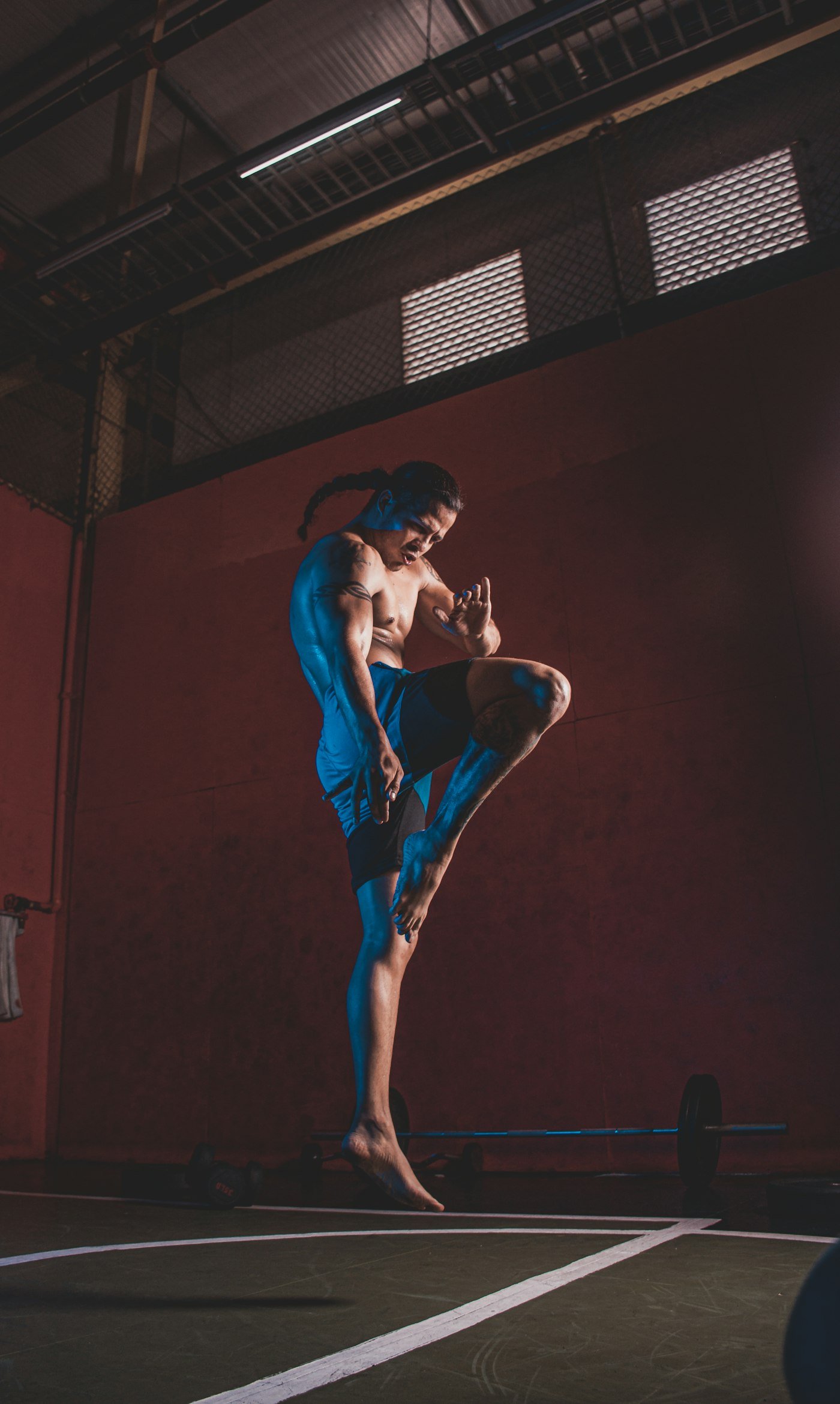 Deportista entrenando patada en el gimnasio
