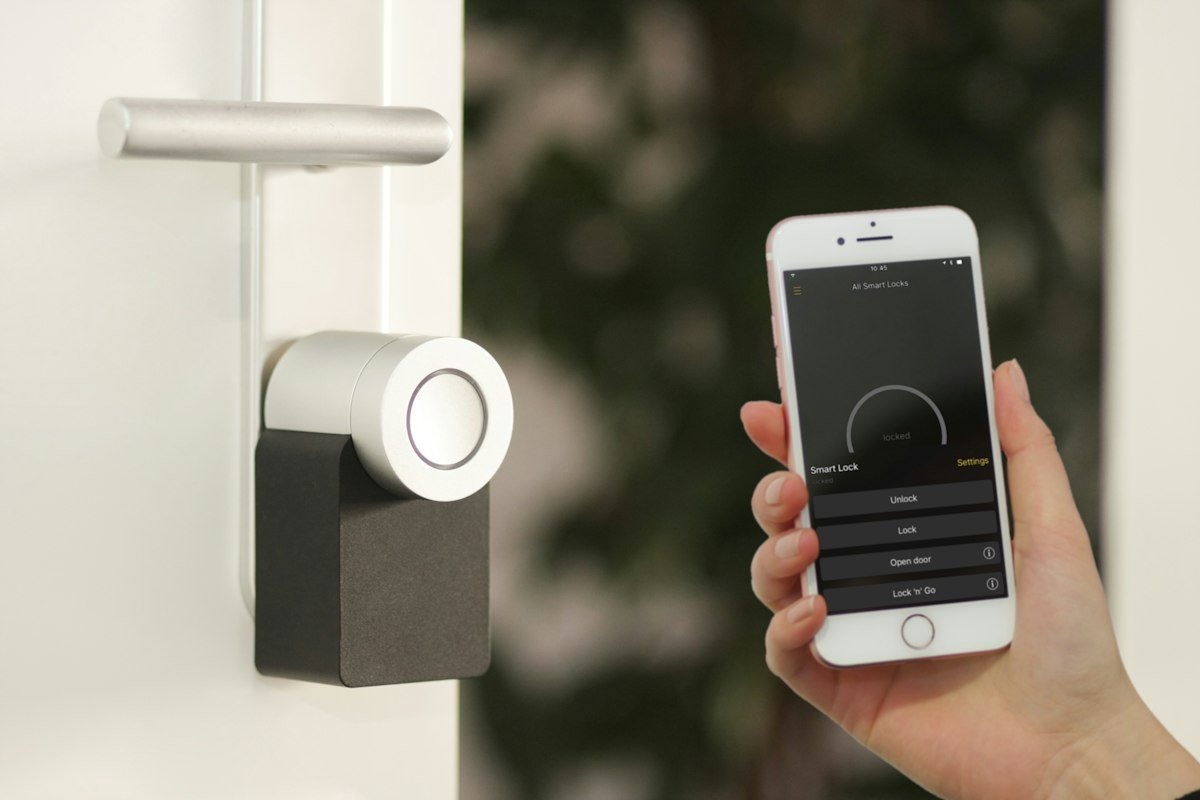 Móvil junto a una puerta con cerradura inteligente