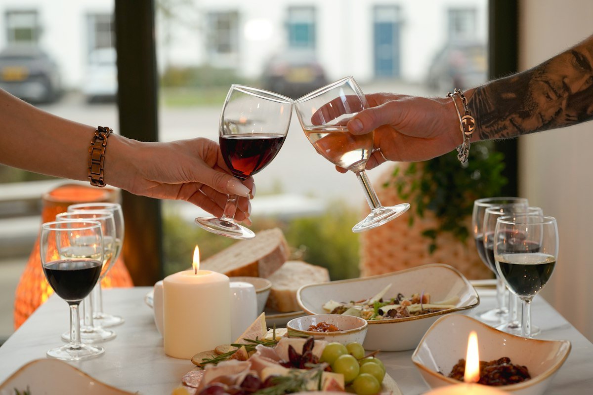 Dos copas de vino brindando sobre una mesa puesta