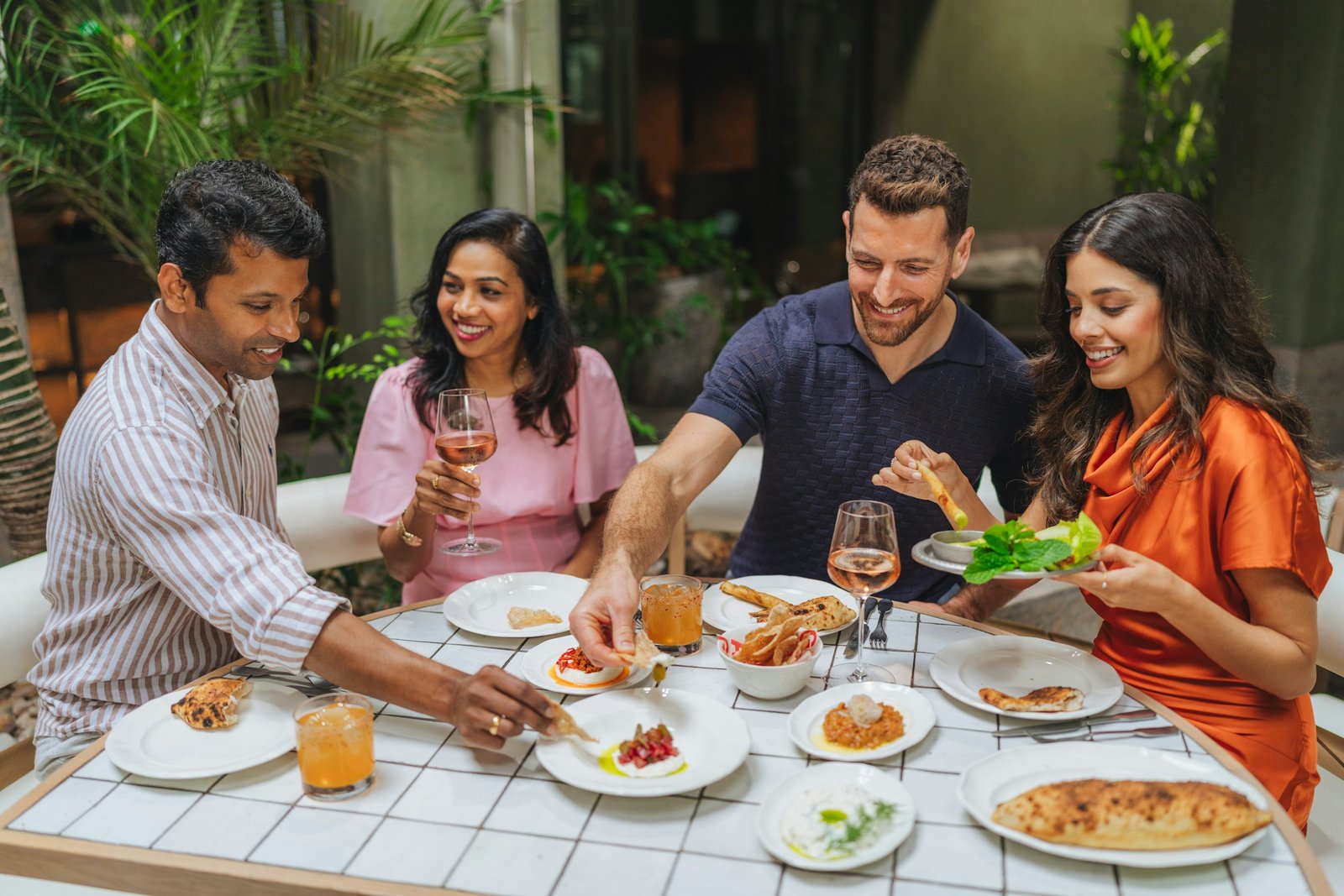 Grupo de amigos compartiendo platillos y bebidas en un restaurante